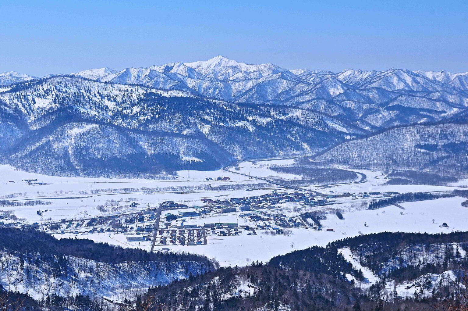 雪に覆われた音威子府村の家並みと、周囲に広がる山々